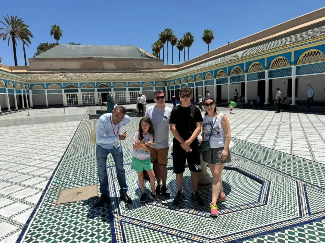 Youssef with a family in the tiled courtyard of a Marrakech palace