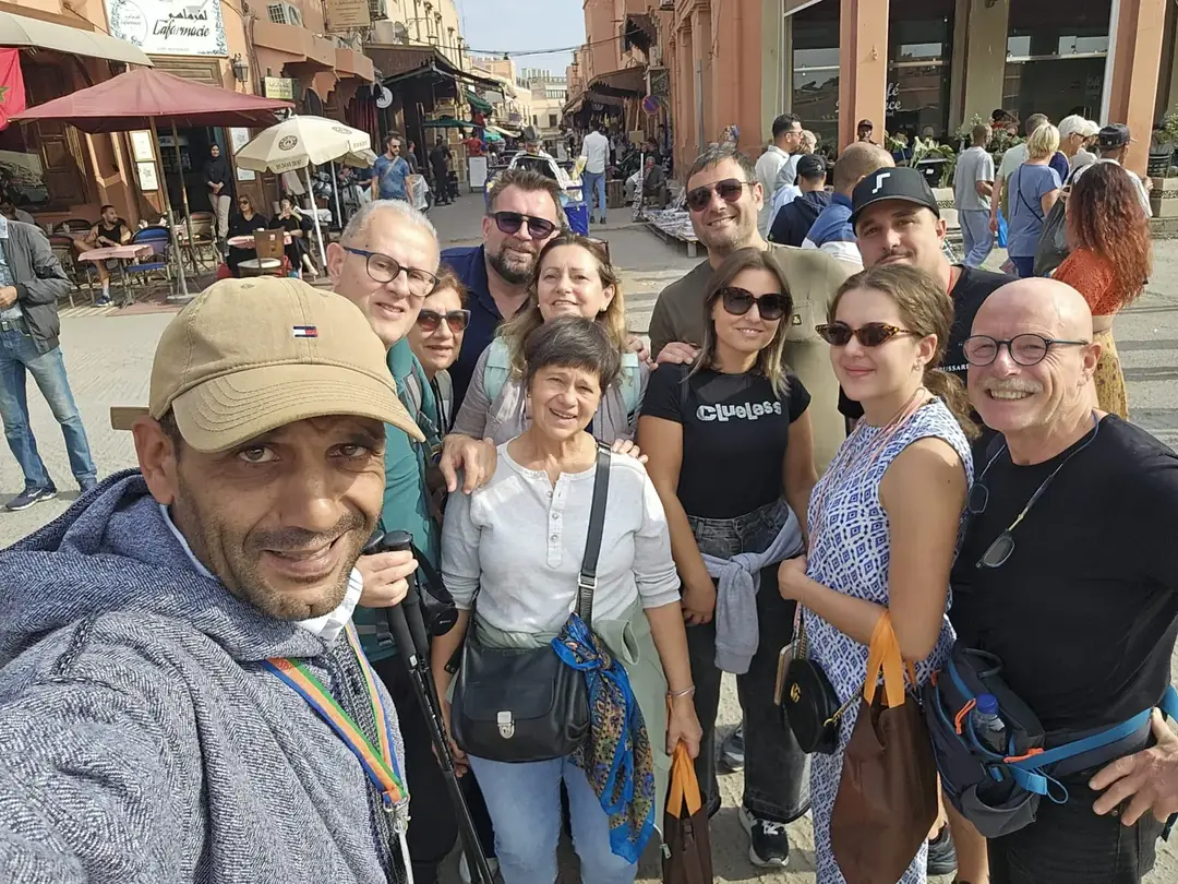 Youssef taking a selfie with a group in a Marrakech souk street