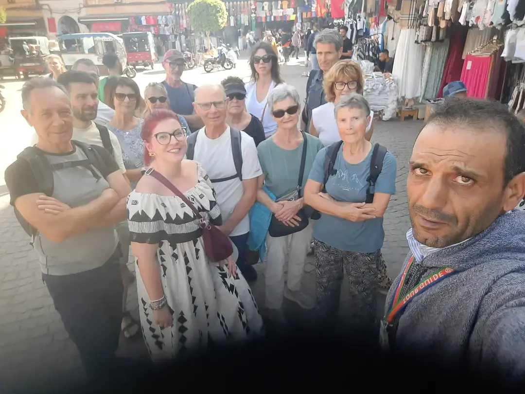 Youssef with a group of travellers in a sunny souk