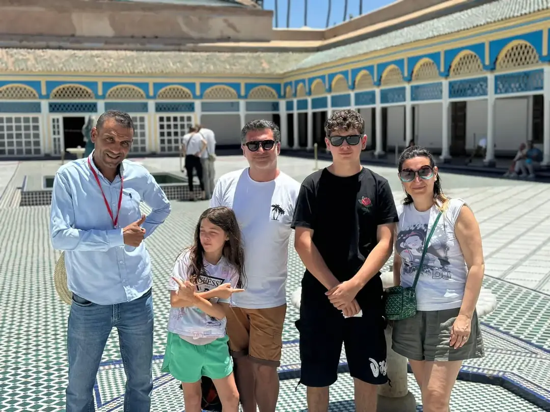 Youssef with a family in a tiled palace courtyard in Marrakech