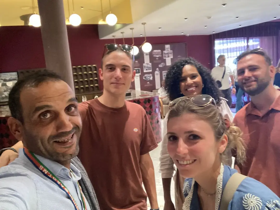 Youssef with travellers in a café with colourful lighting