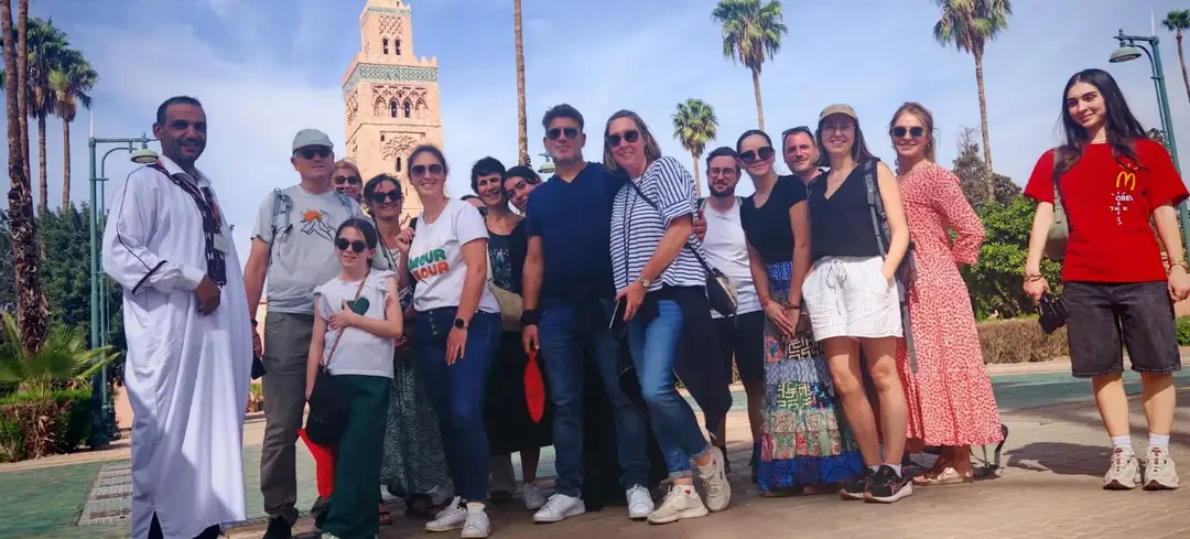 A group of guests with Youssef beside the Koutoubia Mosque