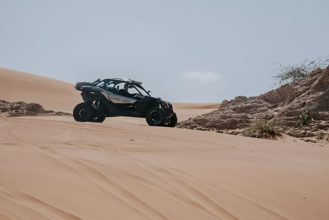 A dune buggy on a sandy ridge among rocks